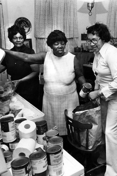 Gertrude Snodgrass, second from left, and other volunteers pack food to be given away in her West Side neighborhood