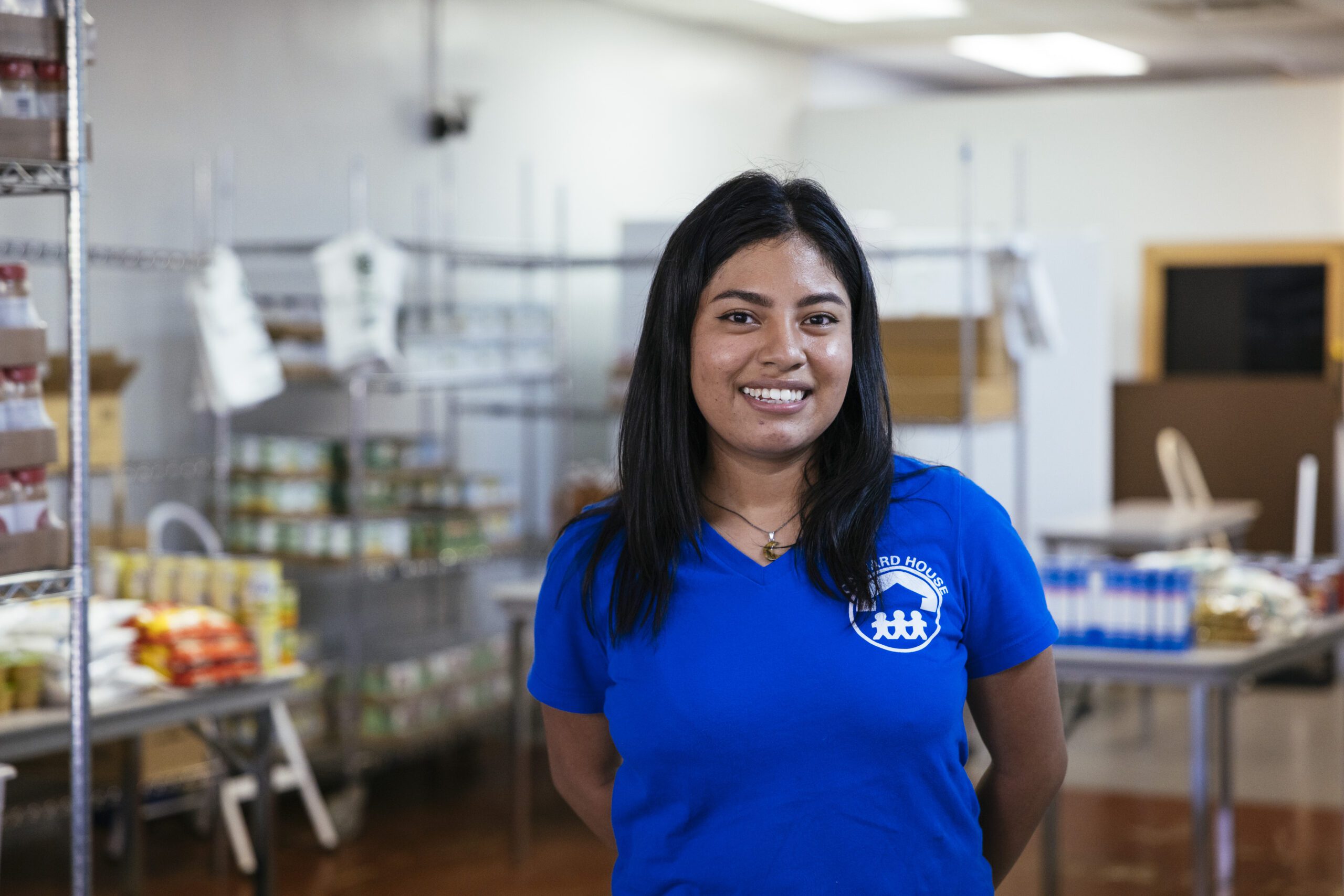 A food pantry staff member smiles at the camera