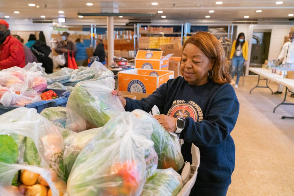 a woman organizes food at a food pantry