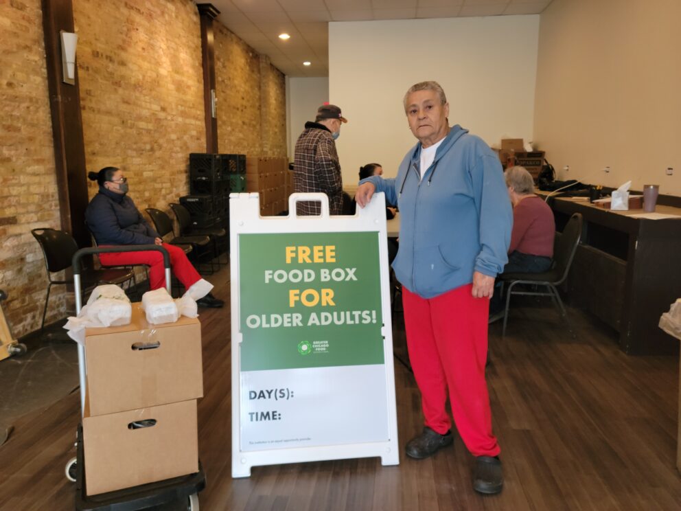 a woman stands next to a sign for a food pantry