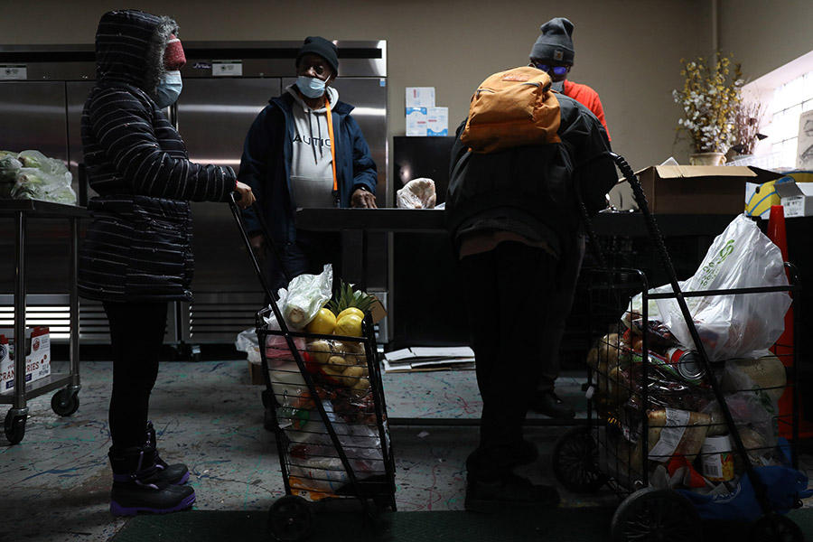 La gente hace fila en una despensa de alimentos.