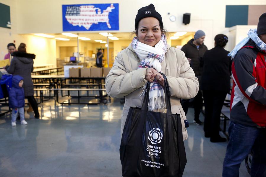 Un miembro de la comunidad con su bolsa llena de comida que consiguió en una despensa en nuestra red.