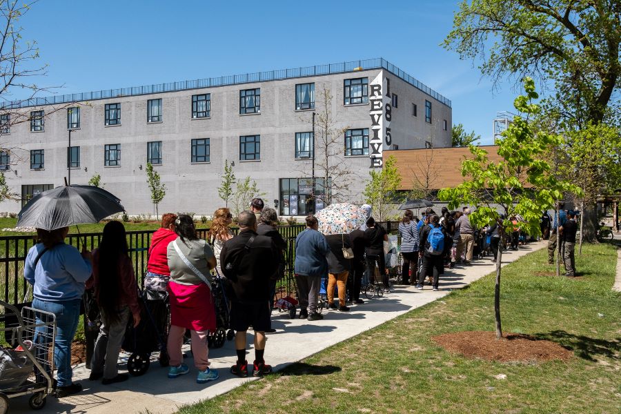 People wait outside in line.