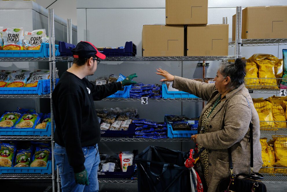 A woman and a man point to an item on a shelf.