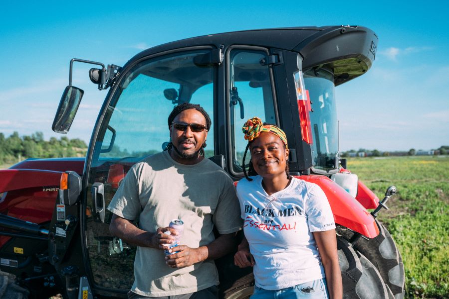 Dos personas se encuentran delante de un tractor.